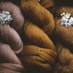 quatre écheveaux de laine teints naturellement avec de l'oignon et quelques petites fleurs blanches