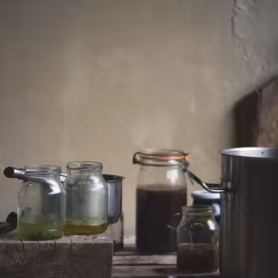 différents récipients contenant des décoction de plantes pour la teinture naturelle