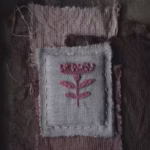 borderie rose sur tissu de lin. Une fleur brodée avec des fils teints naturellement