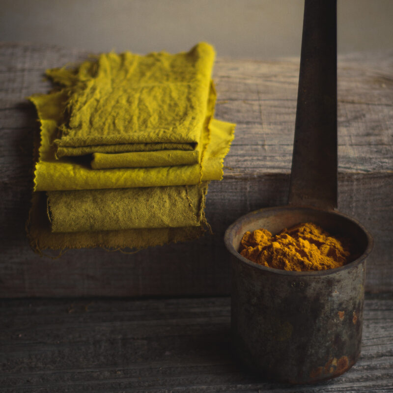 Poudre de curcuma et coupons de lin teints en jaune
